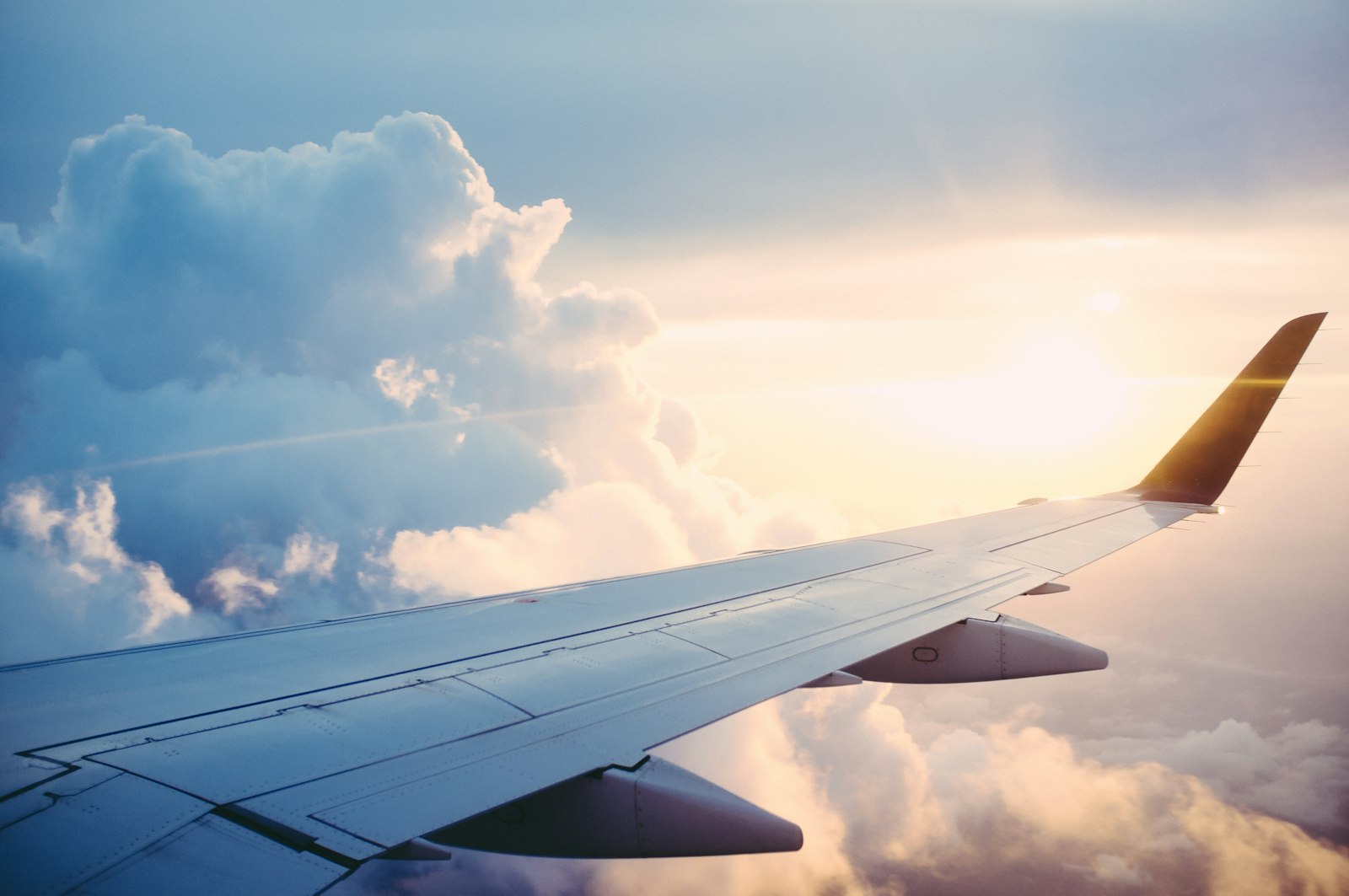Ala de avión sobre un mar de nubes al atardecer